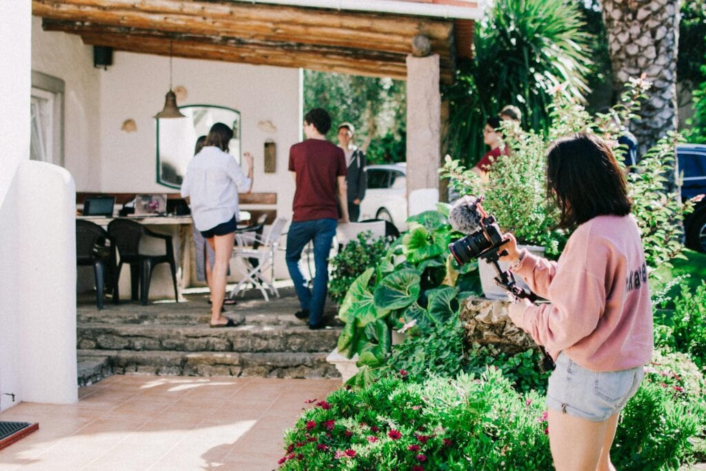Hobbies to start in your 20s: A woman filming a group of friends
