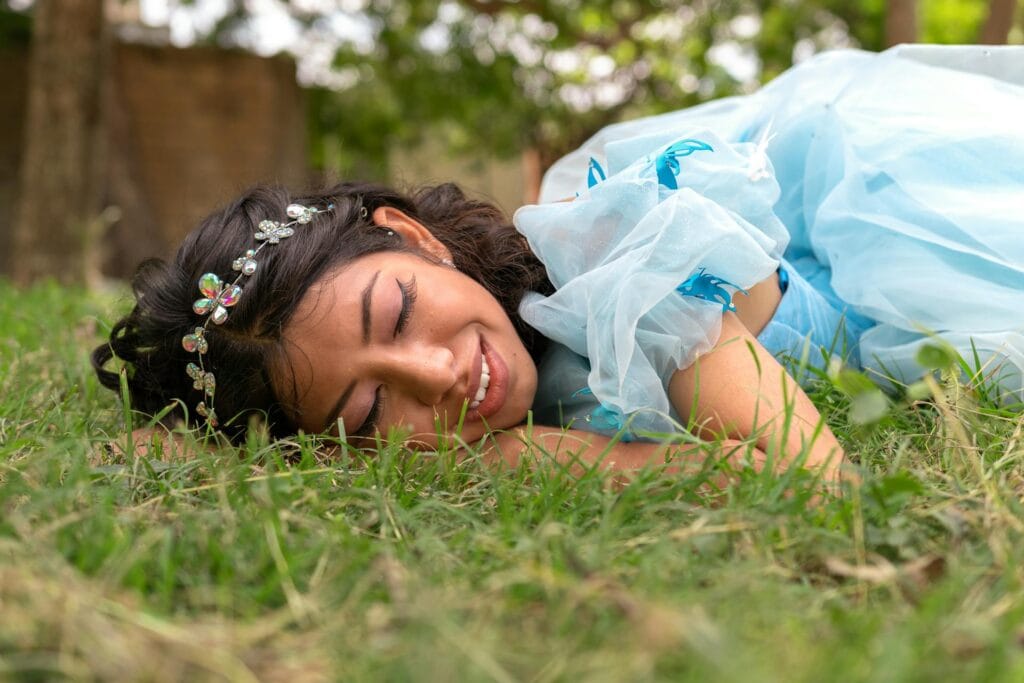 A smiling woman lying on the grass.