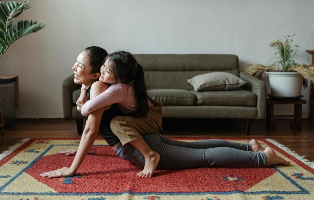 Characteristics of a patient person: A woman and her child doing yoga.