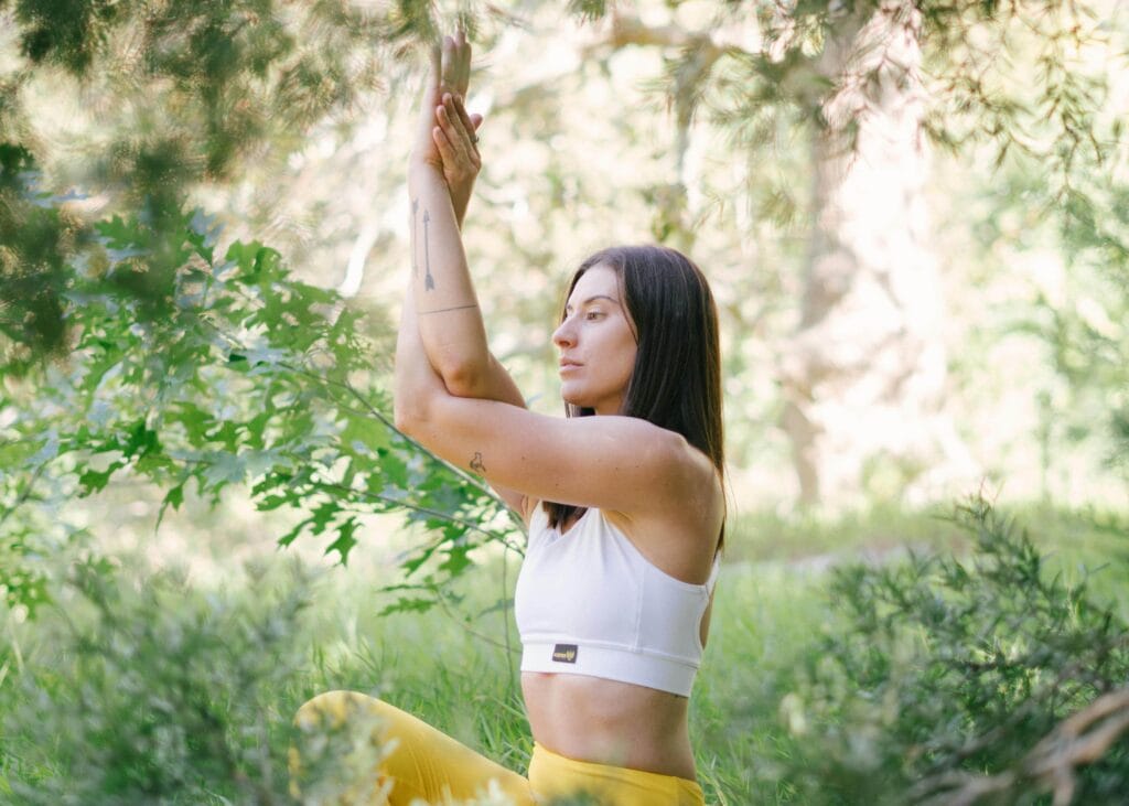 Woman in the woods doing yoga or meditation - How The Law Of Cause And Effect Can Transform Your Life