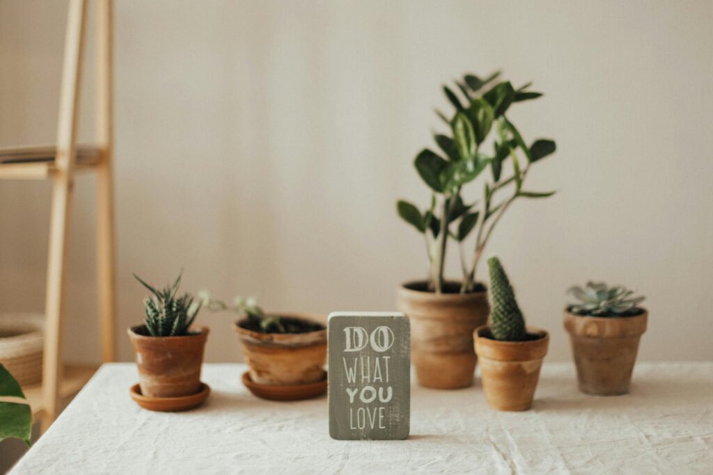 A "Do what you love" plate in front of plants.