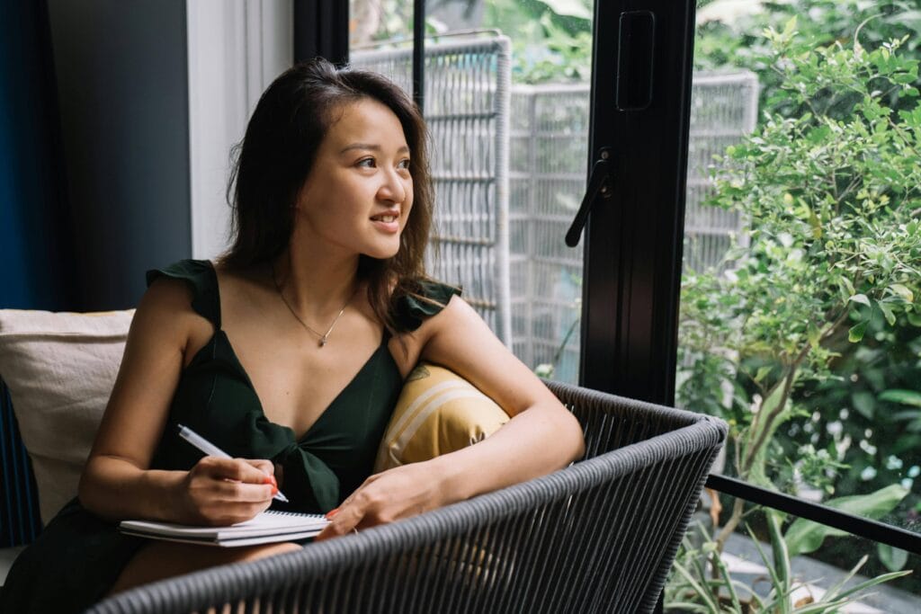 Woman writing down affirmations - 100+ New Month Affirmations To Uplift Your Spirit And Goals