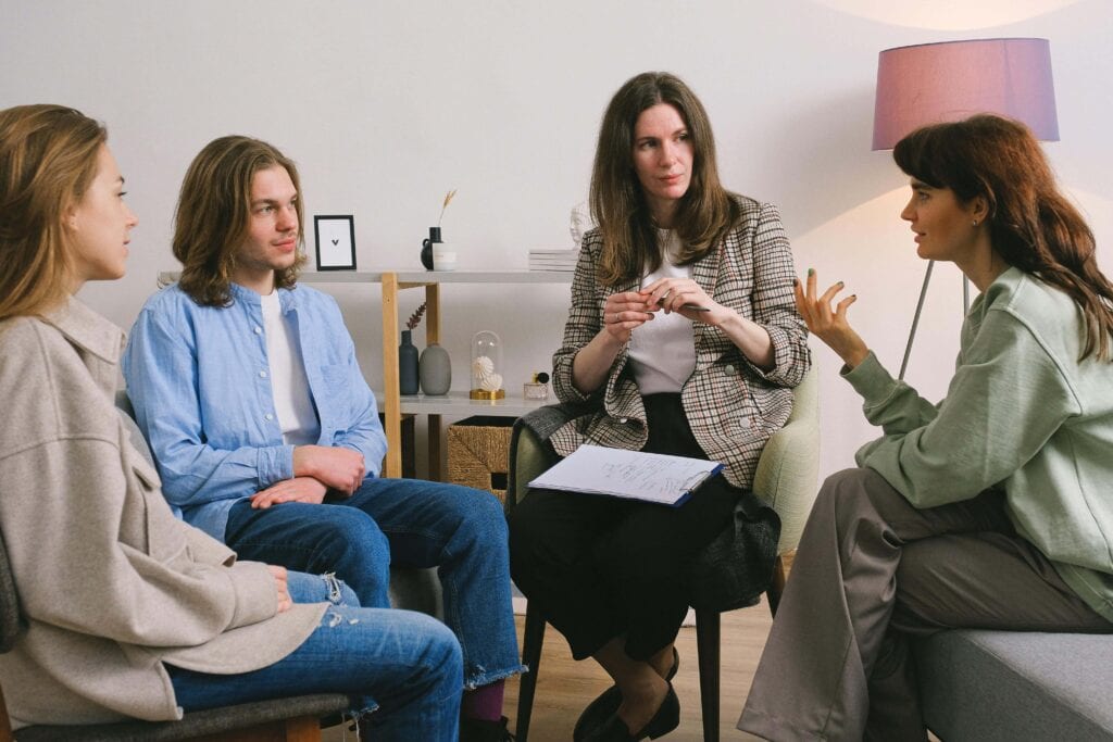 Group of people where one is talking and the others are listening - 11 Tips On How To Be A Better Listener In A Relationship