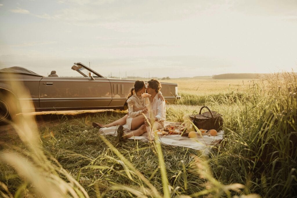 Couple in a field having a romantic picnic together. - 11 Hacks On How To Be More Intentional In A Relationship