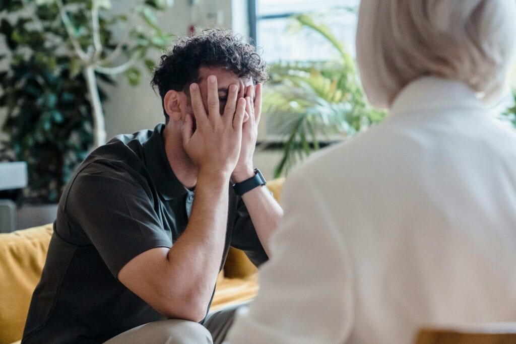 A man with his hands for his face, clearly being upset. - Empathy Burnout: How To Sustain Empathy In Difficult Times