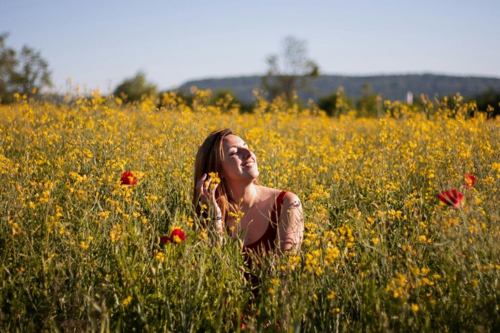 Happy woman in flower field - The Law Of Attraction Could Be Your Way To Success In Life