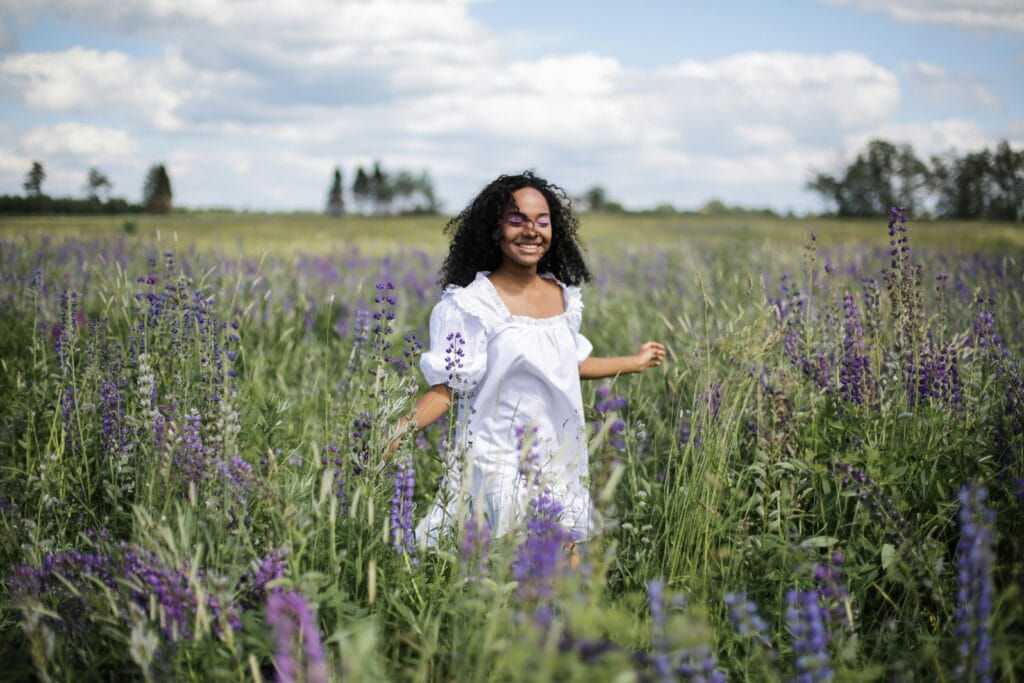 Happy woman in a field of flowers - Law Of Relativity: Transform Your Perspective For Growth
