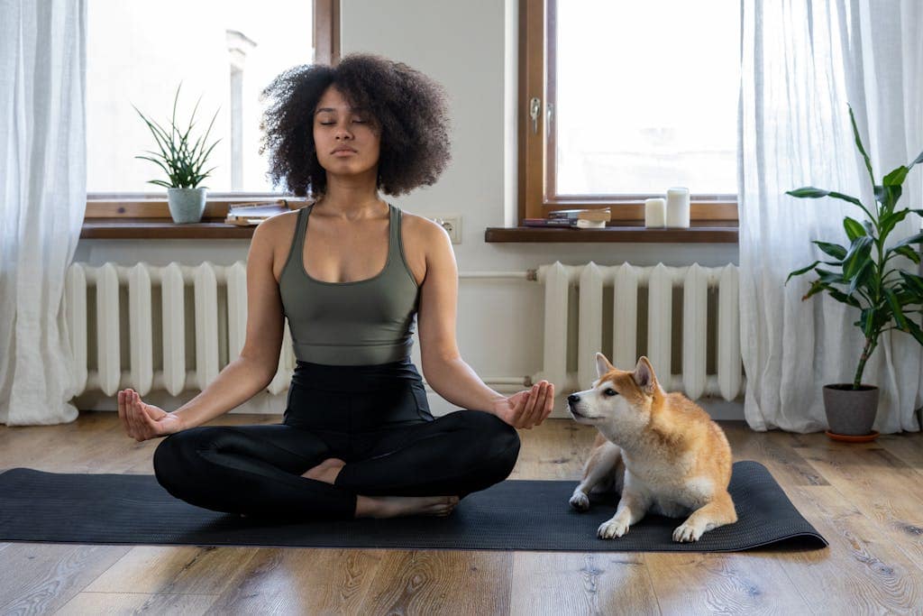 Woman meditating on yoga mat with Shiba Inu dog indoors. Calm and serene home setting. - 11 Ways To Reprogram The Subconscious Mind For Success